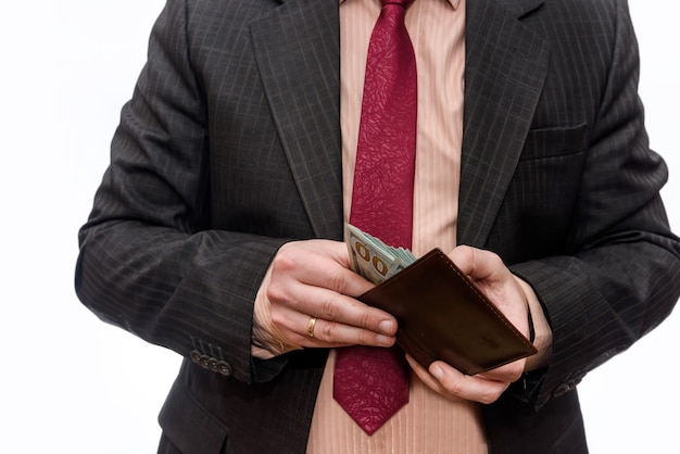 Male hands holding wallet full of dollar banknotes close up