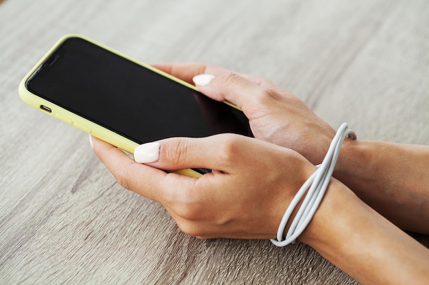 Male hands tied with chain and hold smartphone