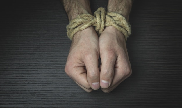 Male hands tied with a rope