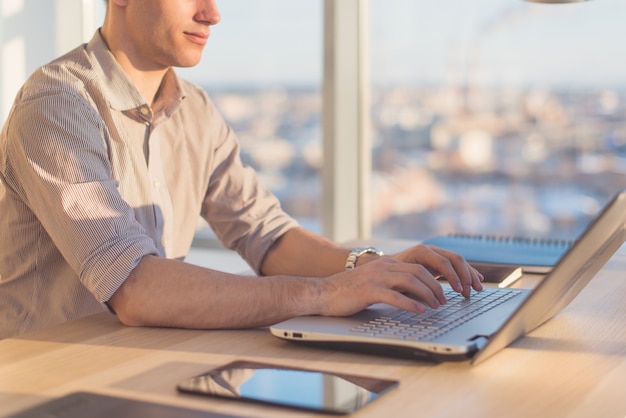 Male hands typing, using laptop in office. Designer working at workplace