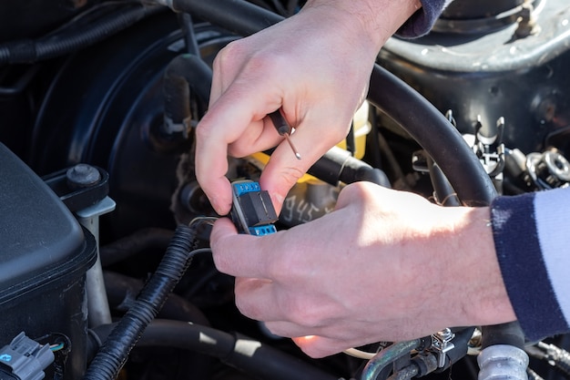 Male hands with a small screwdriver connect an electronic component