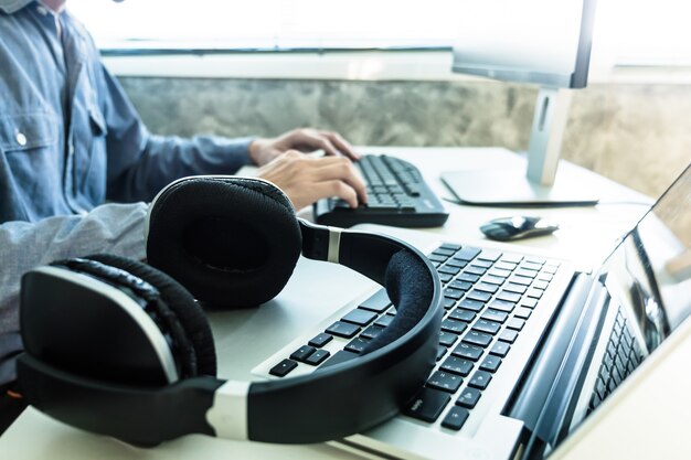 Male hands working on computer with headphones, Sound engineer concept