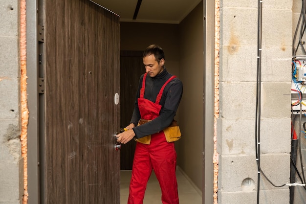 Male handyman carpenter at interior wood door lock installation.