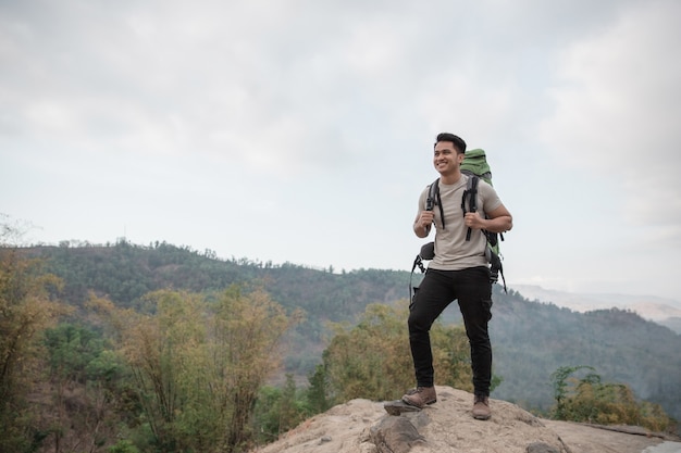 Male hiker reach the top