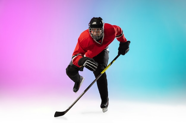 Male hockey player with the stick on ice court