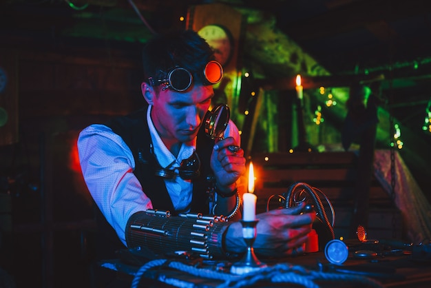 Male inventor in a steampunk suit repairs a fantastic mechanism at a table