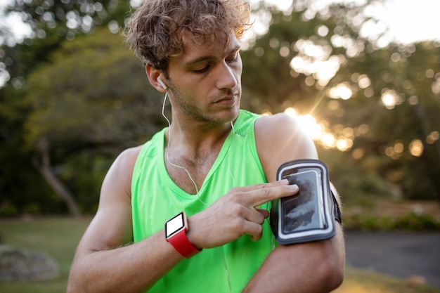 Male jogger listening to music on mobile phone