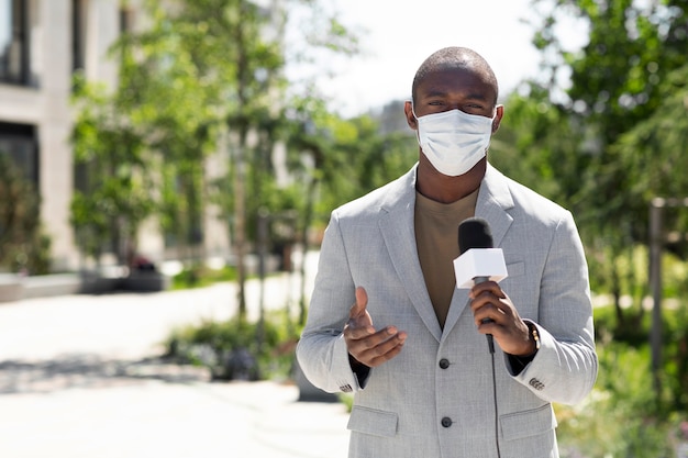 Male journalist wearing a medical mask