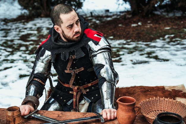 Male knight sits at a wooden table