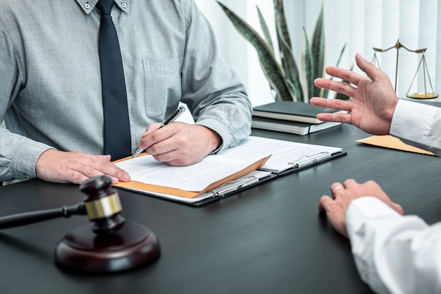 Male lawyer discussing negotiation legal case with client meeting with document contact in courtroom, law and justice concept.