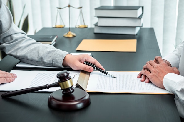 Male lawyer discussing negotiation legal case with client meeting with document contact in courtroom, law and justice concept.