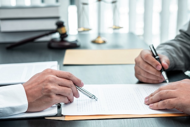 Male lawyer discussing negotiation legal case with client meeting with document contact in courtroom, law and justice concept.