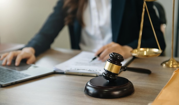 Male lawyer in the office with brass scale on wooden table justice and law concept