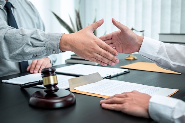 Male lawyer shaking hands with client after good deal negotiation cooperation meeting in courtroom