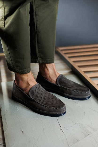 Male legs closeup in jeans and beige genuine leather moccasins