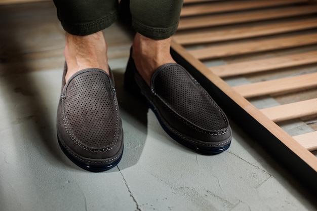 Male legs closeup in jeans and beige genuine leather moccasins