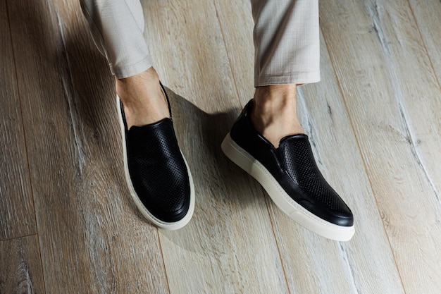 Male legs in leather shoes Comfortable men's black shoes without laces Casual men's moccasins