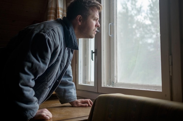 Male looking out of window during quarantine of covid 2019 Spy on neighbors concept