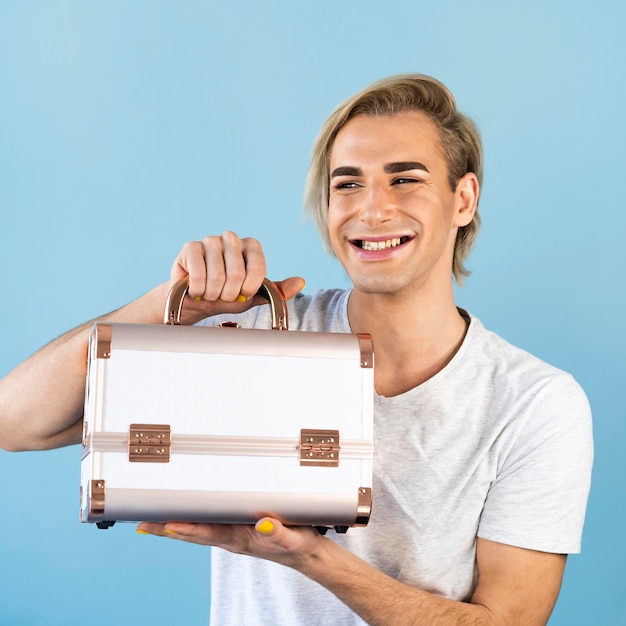 Male make-up look holding a cosmetics box