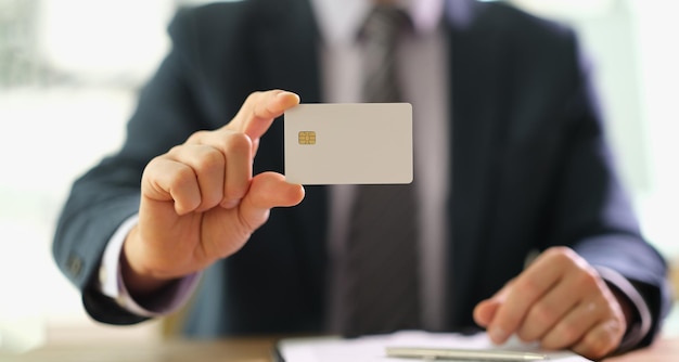 Male manager in suit holding plastic credit card closeup