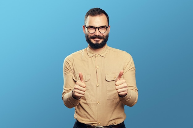 Male manager with beard wearing glasses and showing thumbs up happily on