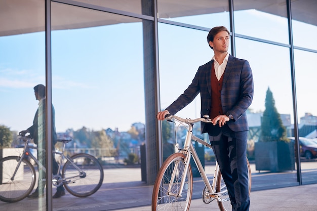 Male manager with bike on city street