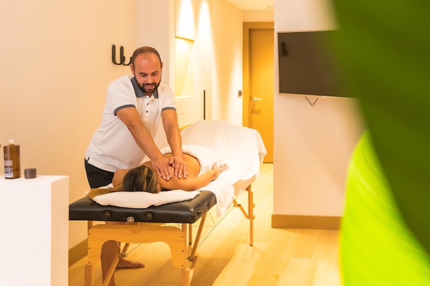 Male masseur performing a massage on the table to a client