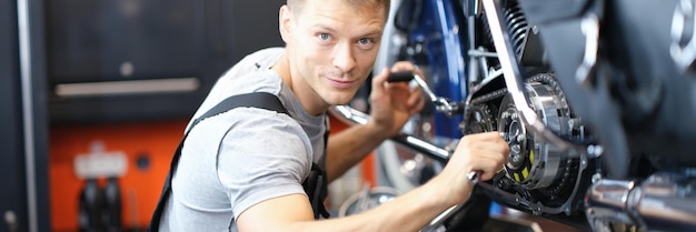 Male mechanic in a garage repairing a motorcycle