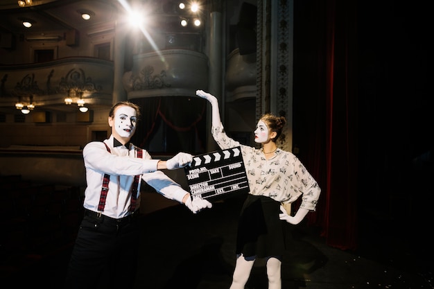 Male mime artist standing in front of female mime artist on stage