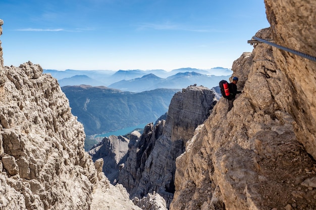 Male mountain climber on a Via Ferrata in breathtaking landscape of Dolomites Mountains in Italy