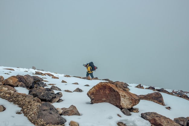 Male Mountain Climber Walking Uphill On Frozen Snow