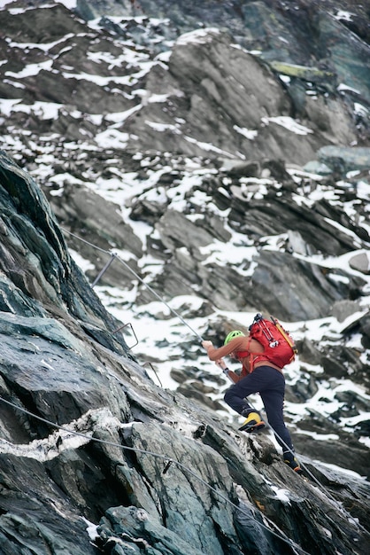 Male mountaineer climbing rocky mountain