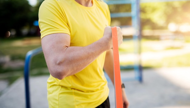 Male muscular arm with elastic rubber band in street