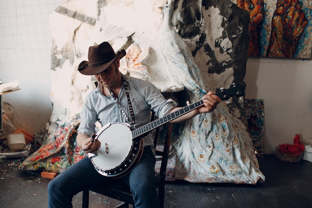 Male musician playing banjo sitting chair indoor