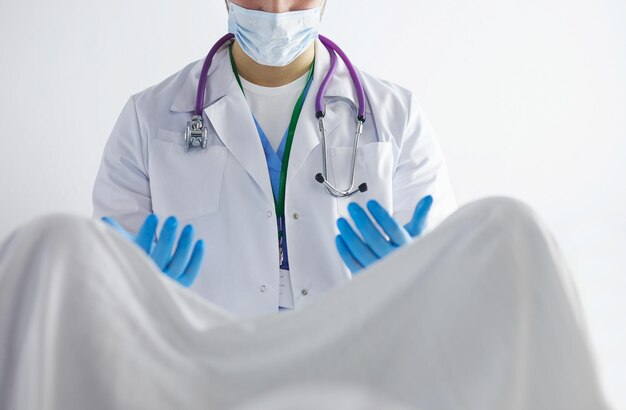 Male obstetrician and scrubs nurse are delivered to the pregnant woman in the delivery room of the hospital