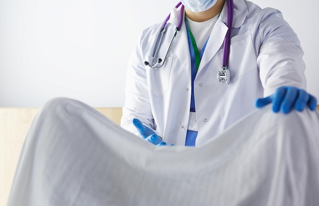 Male obstetrician and scrubs nurse are delivered to the pregnant woman in the delivery room of the hospital