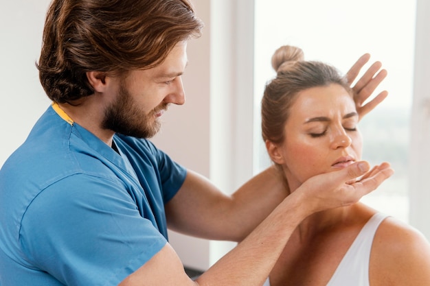 Photo male osteopathic therapist checking female patient's neck