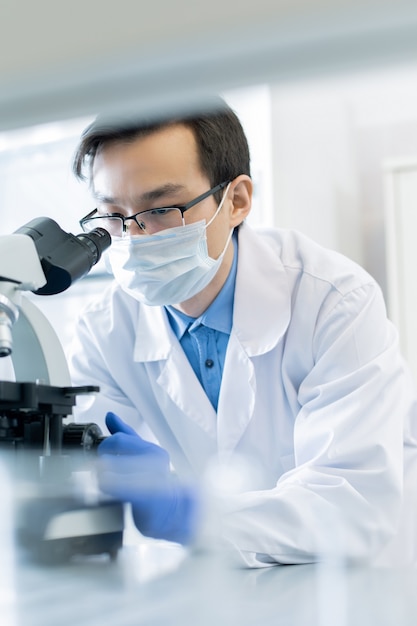 Male Parmacologist Using Microscope