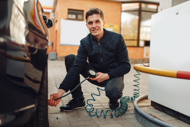 Male person checks the tire pressure