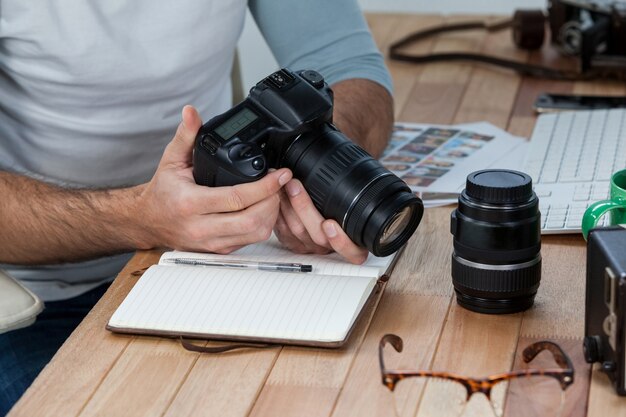 Photo male photographer reviewing captured photos in his digital camera