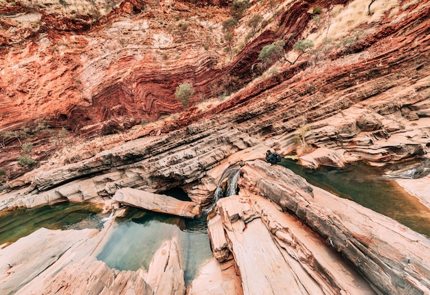 A male photographer shooting diagonal and curve shapes of Hamersley Gorge, Karijini.