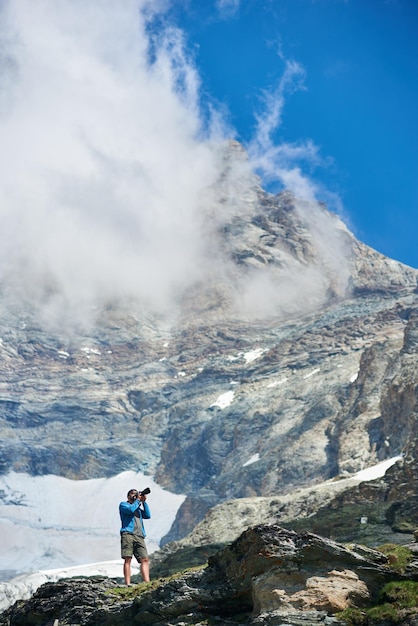 Male photographer taking picture in mountains