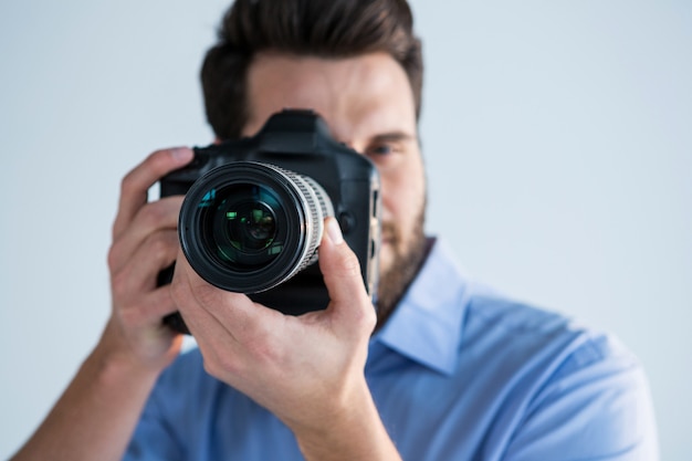 Male photographer with digital camera in studio