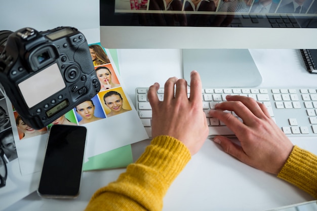 Male photographer working over computer at desk