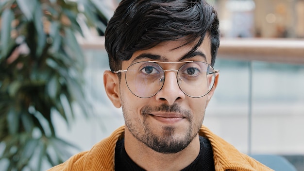 Male portrait headshot young positive handsome indian guy looking at camera confident bearded man