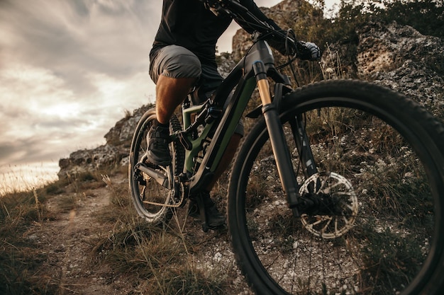 Male riding mountain bicycle in cloudy evening