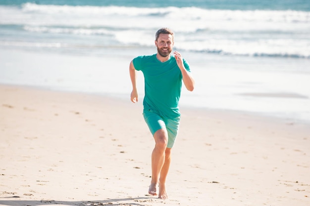 Male runner athlete run on sandy beach man running