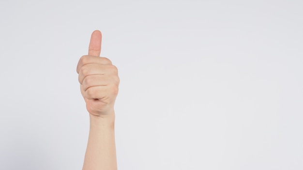 Male's left hand doing thumbs up sign on white background.