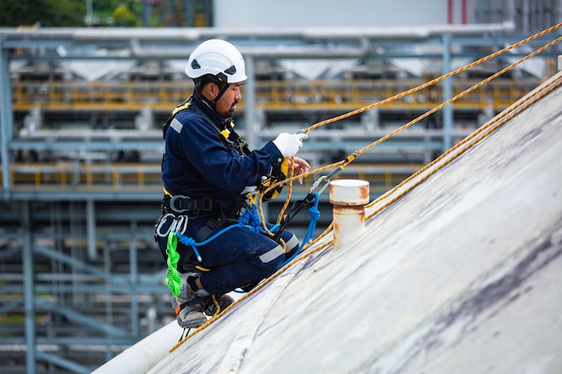 Male sitdown worker inspection wearing safety first harness rope safety line working at a high