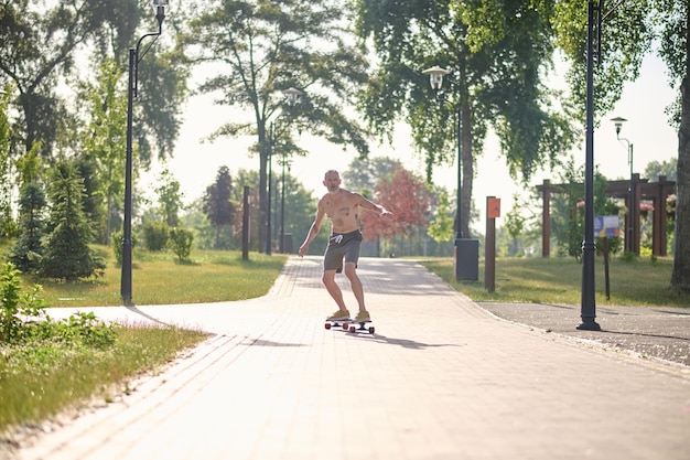 A male skateboarder enjoying a ride in a park